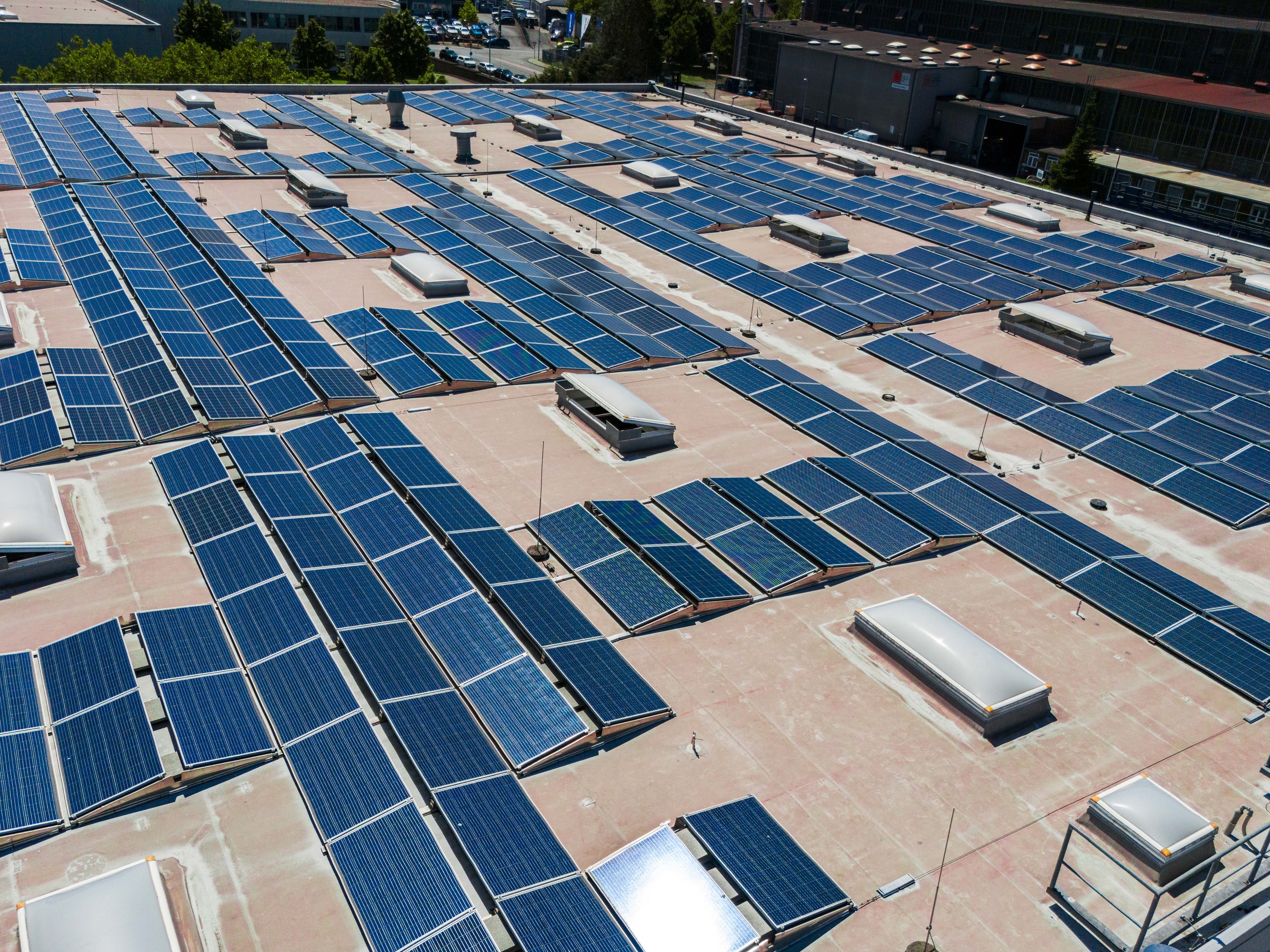 Luftaufnahme einer großen Photovoltaikanlage auf einem Hallendach